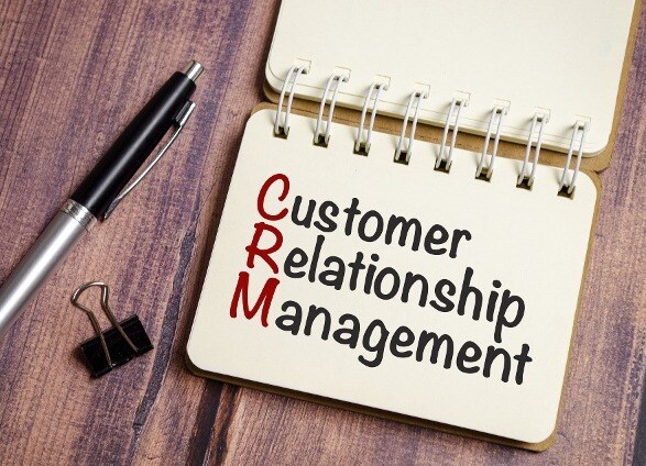 1920-notepad-with-the-text-crm-customer-relationship-management-and-pen-on-wooden-background-1